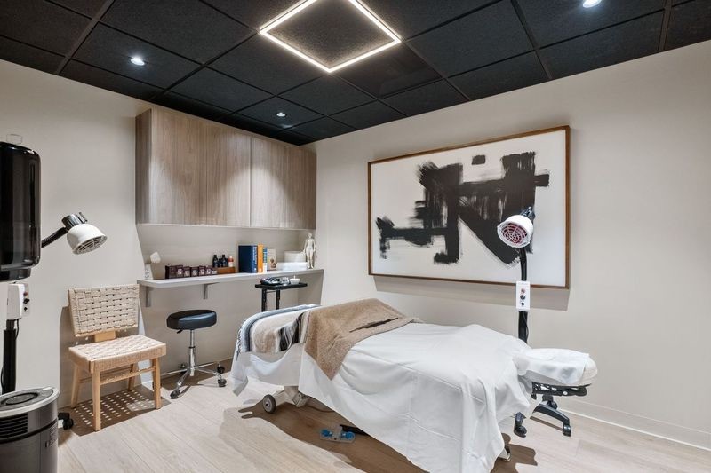 “Modern commercial interior renovation with treatment table, built-in cabinetry, and recessed ceiling lighting”