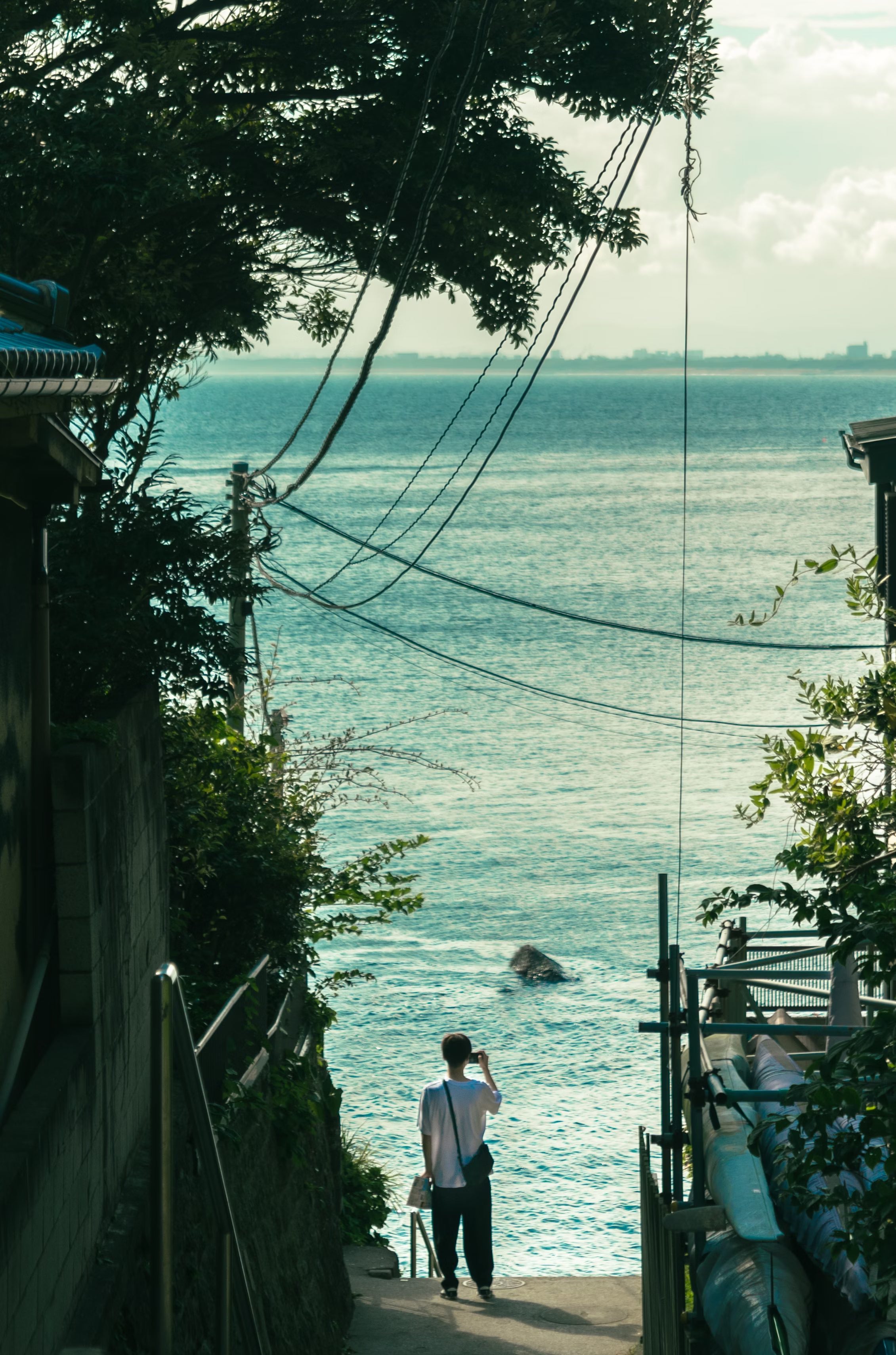 江ノ島からとる海の絶景を写メする人物