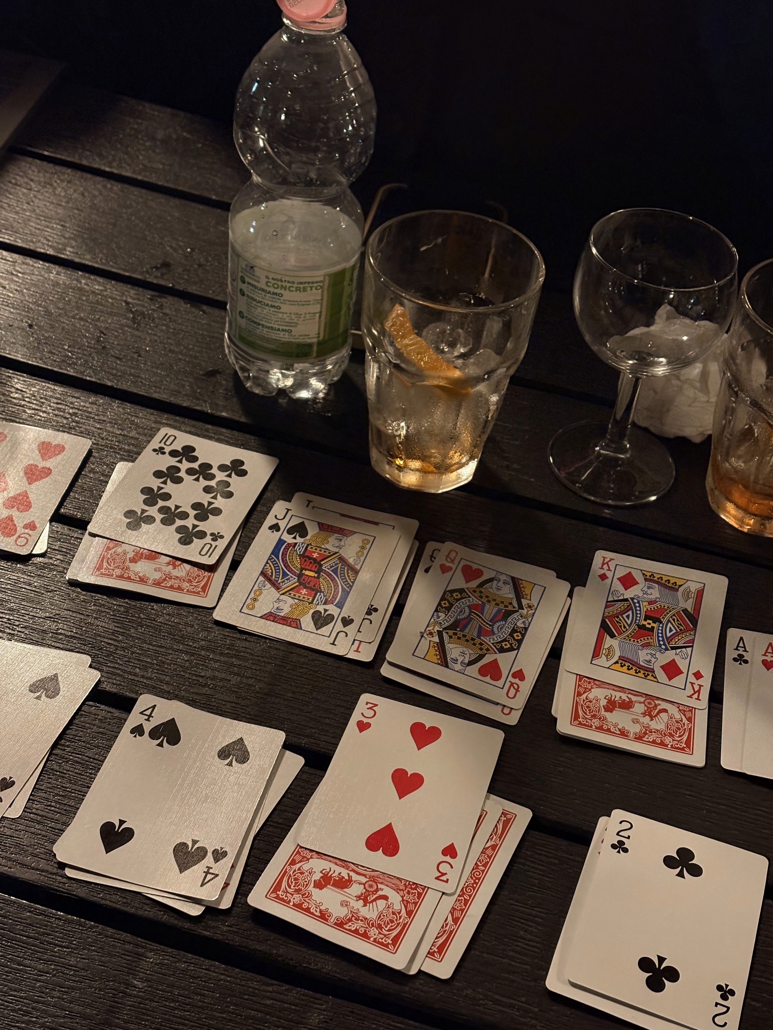A close-up of a hand wearing multiple decorative rings against a blue background.
