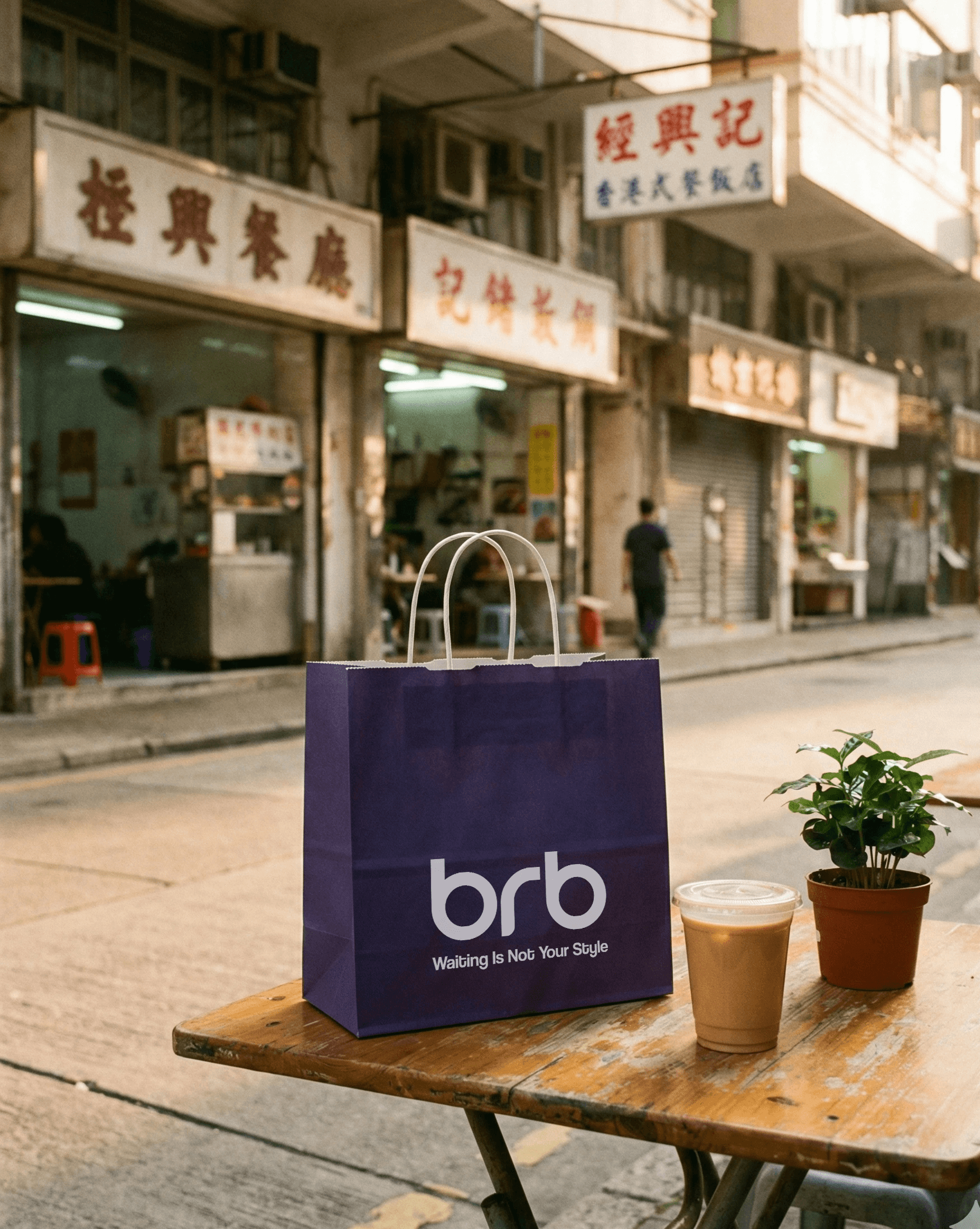 A purple BRB bag placed on a small outdoor table with iced drinks, set in front of traditional Hong Kong shopfronts