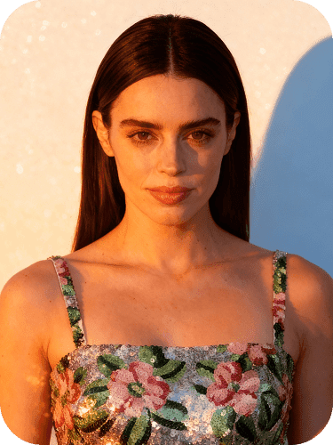 Fashion portrait at golden hour, woman wearing a floral dress against a warm backdrop