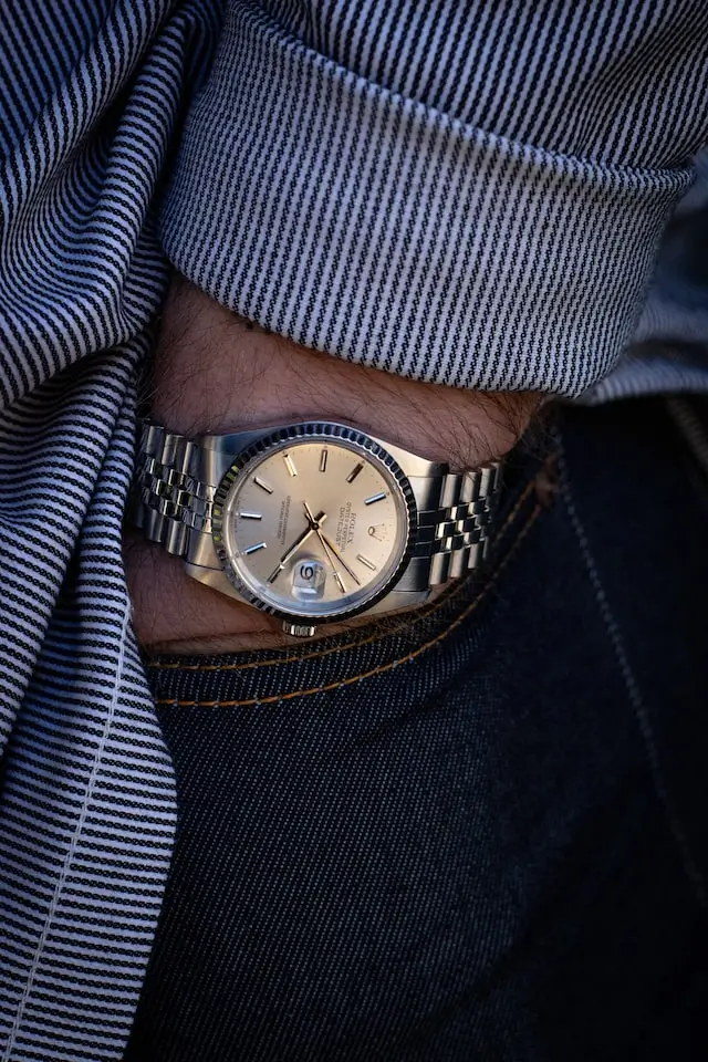 silver Rolex on a hand in a pocket