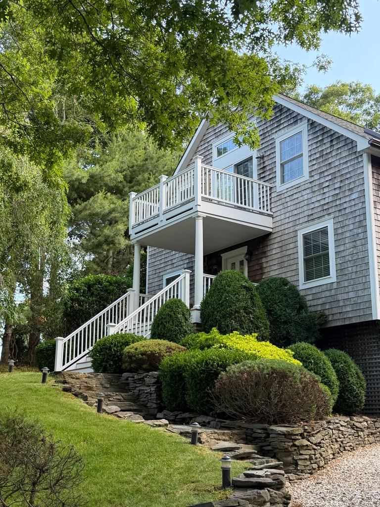 Shingled home with a new front staircase and landscaped paver path
