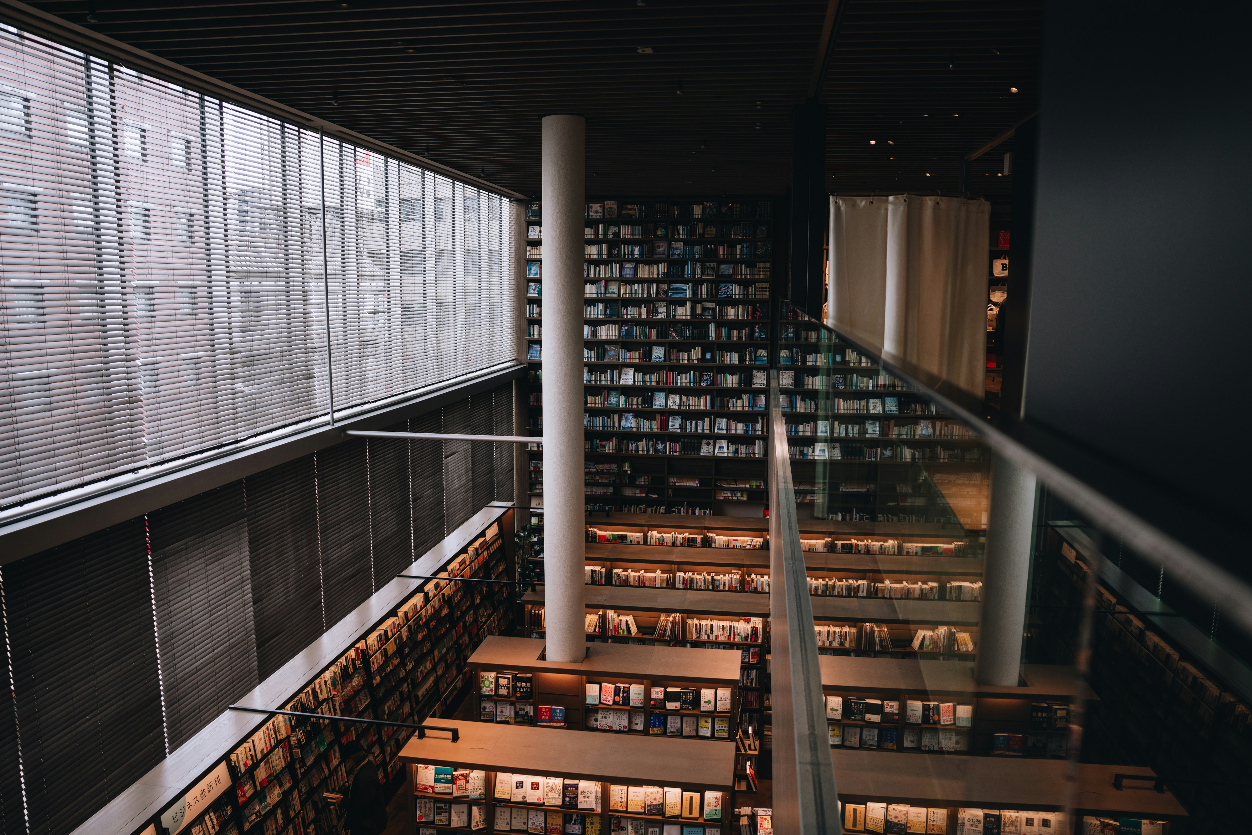 Aerial view of a modern library with natural light pouring in through a large window on the left side