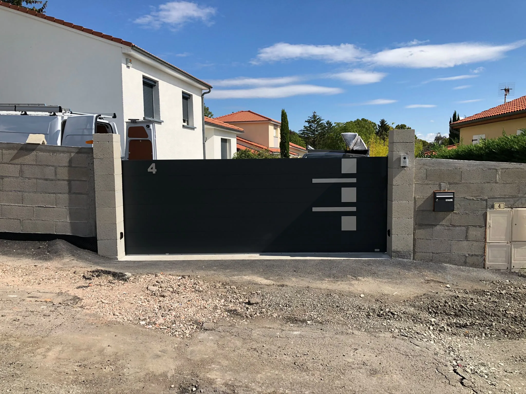 Portail noir entre deux murs en pierre — AFermetures