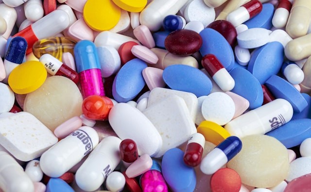 Assorted colorful pills and capsules scattered close together.