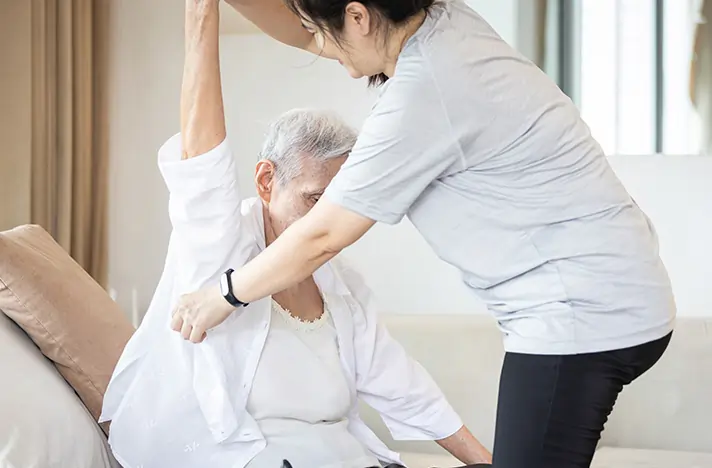 Caregiver providing hands-on personal care to a senior at home
