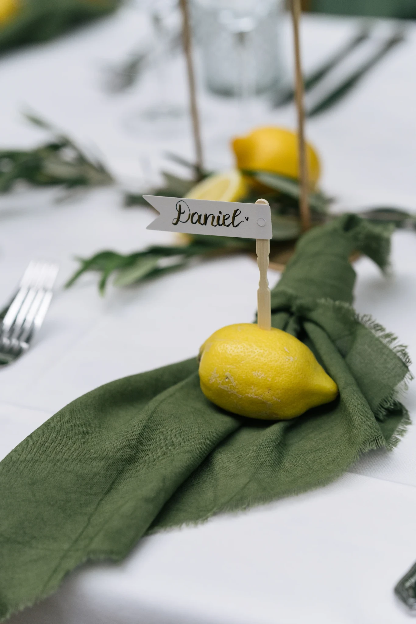 Grüne Serviette mit Namenskarte und Zitrone – Hochzeit N&M in Domat/Ems