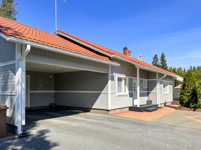 Ulkomaalattu vaalea omakotitalo Seinäjoella, punainen peltikatto ja katettu autopaikka, pelkistetty ja tyylikäs kokonaisuus