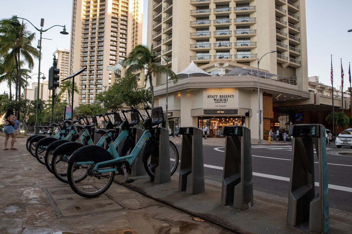 Teal Biki bikeshare bikes docked on a Waikiki street, one way to get around Oahu without a car