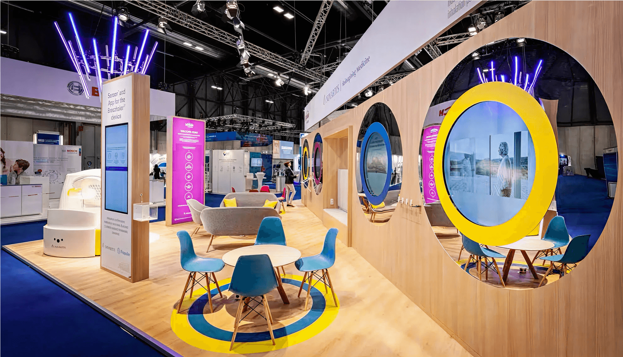 Sustainable booth designs with colorful chairs, tables, and neon lights, with large circular modular exhibit components designed to boost booth traffic, and trade show ROI.