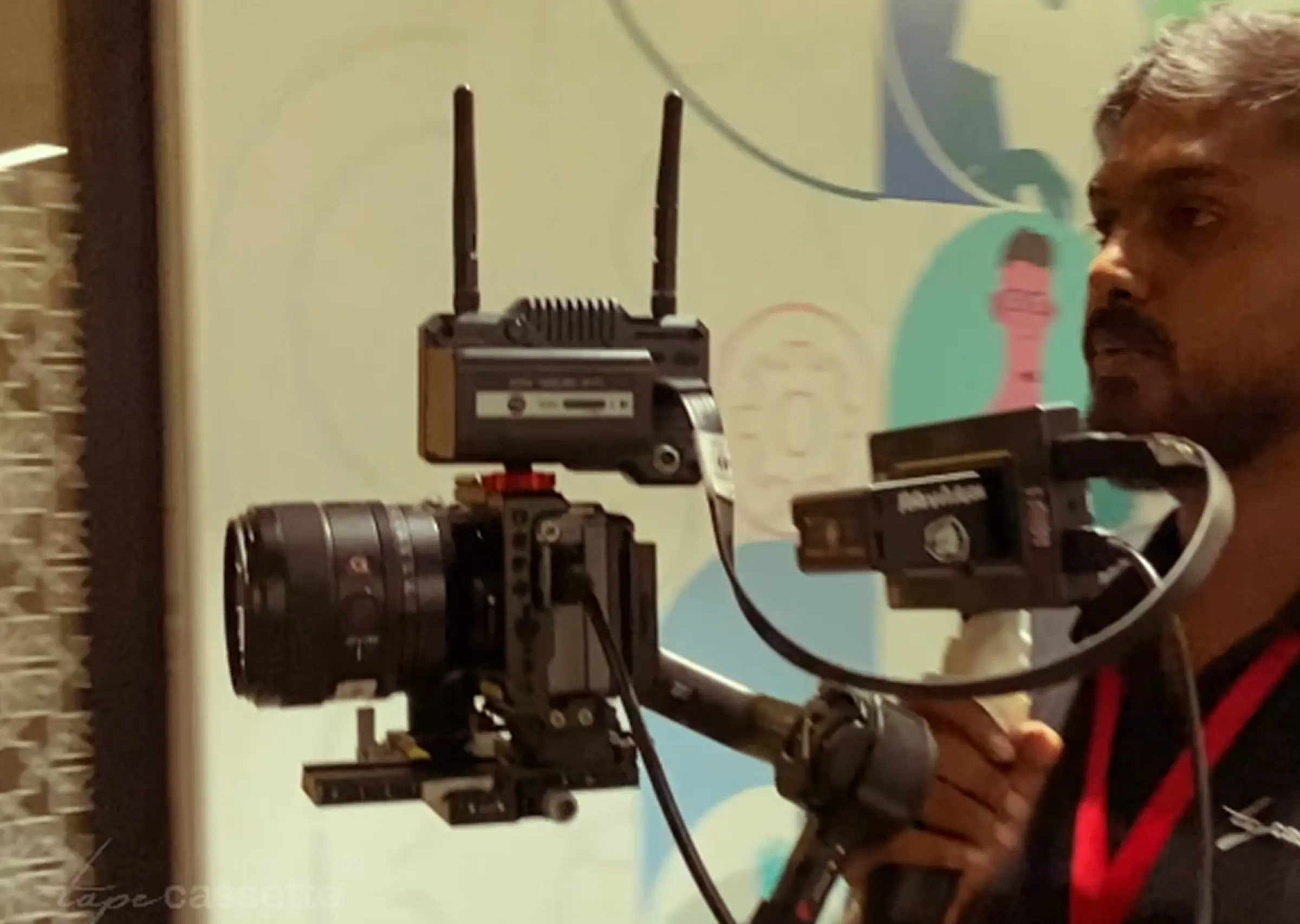 Tapecassette crew filming corporate video with cameras and lighting setup in an indoor studio space