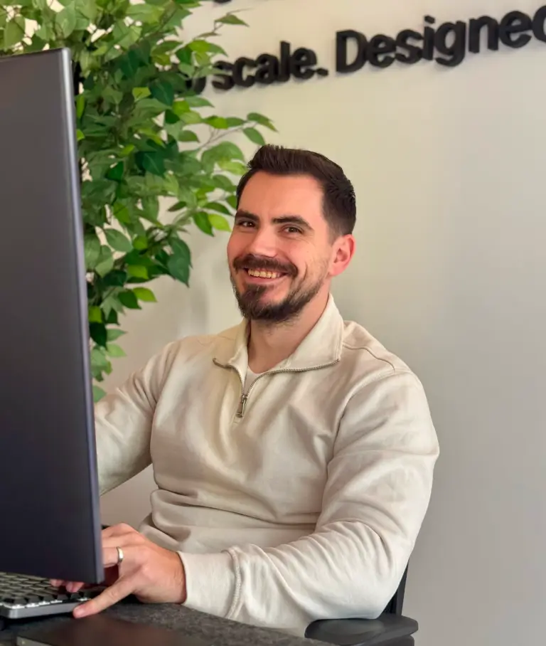 A smiling hadnsome young man, wearing a cap