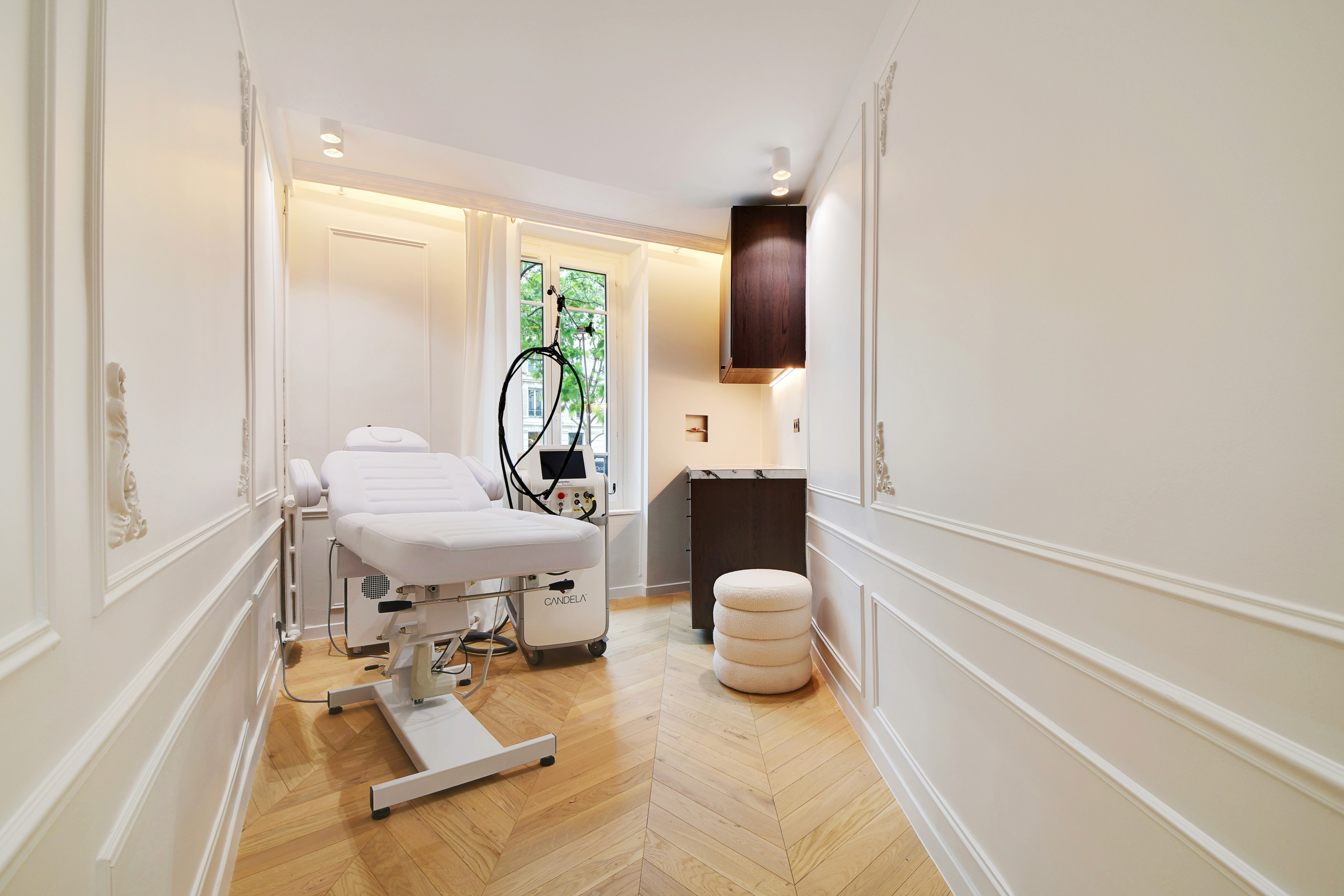 Smiling woman using a rose quartz Gua Sha stone and face roller for a facial massage