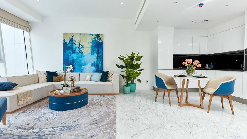 Modern apartment interior highlighting a generous living room and kitchen, from The Pad by OMNIYAT.