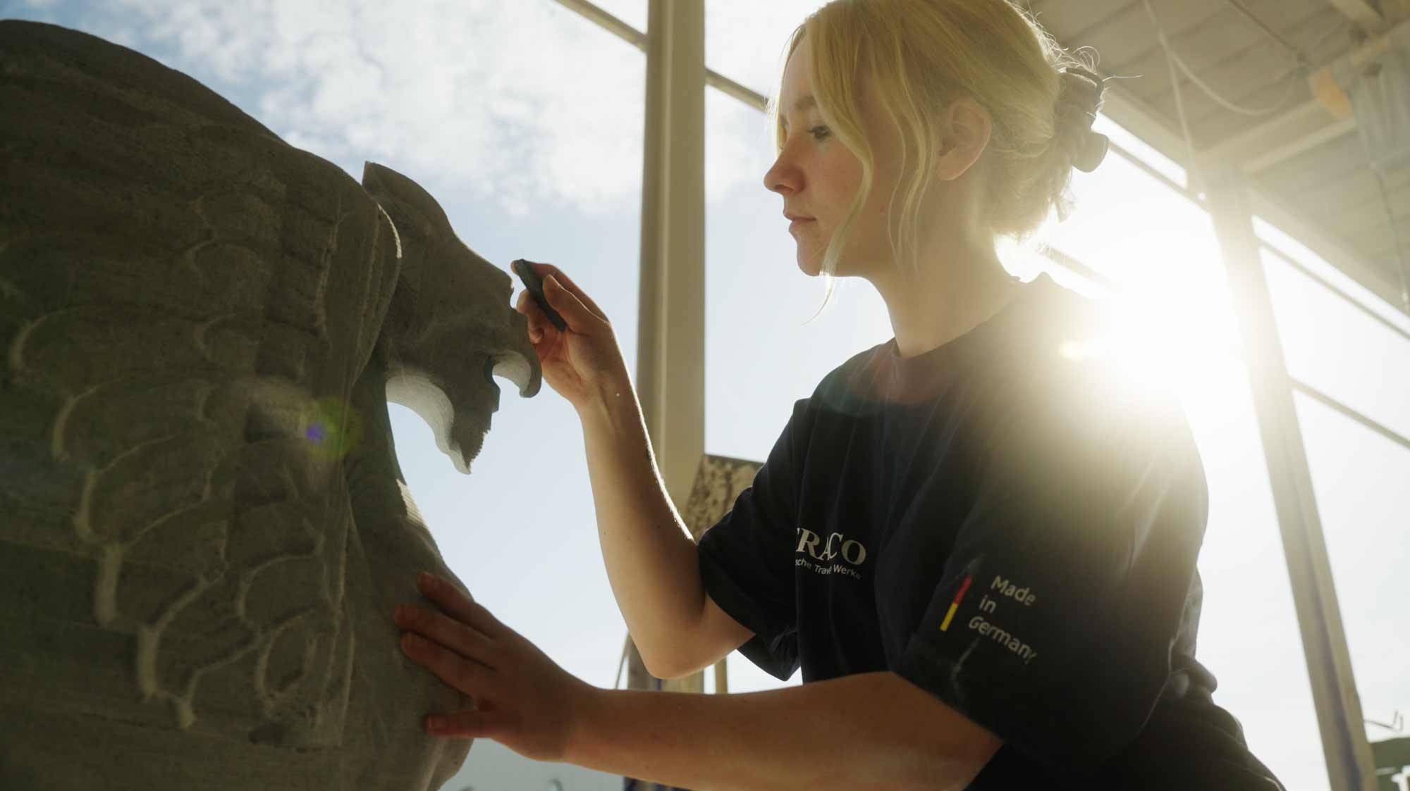 Artist carving stone statue, showcasing storytelling in strategic film production for advertising and social media campaigns.