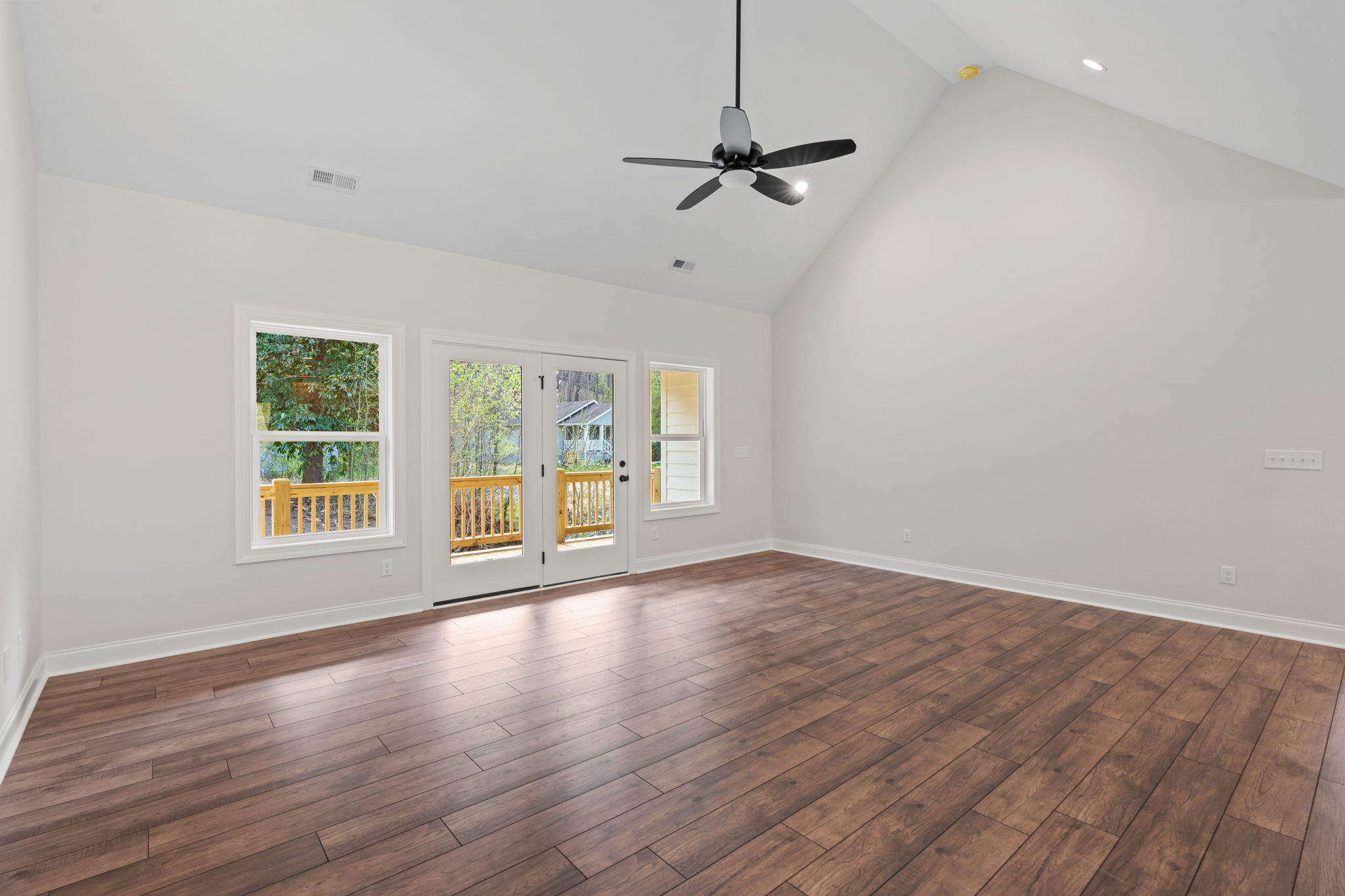 Open concept kitchen and living room with vaulted ceilings and hardwood floors