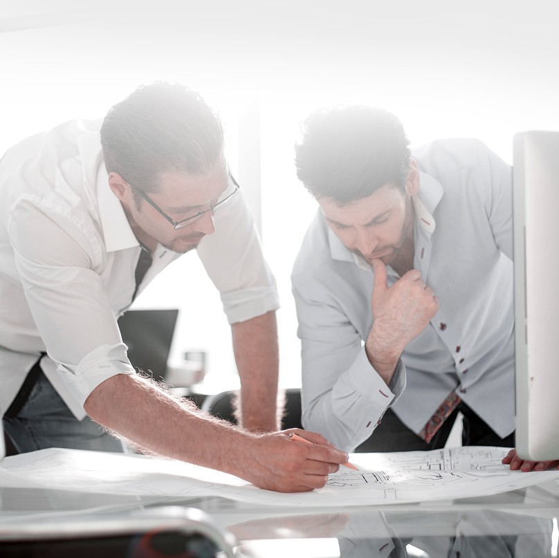 Professionals reviewing plans under pressure.