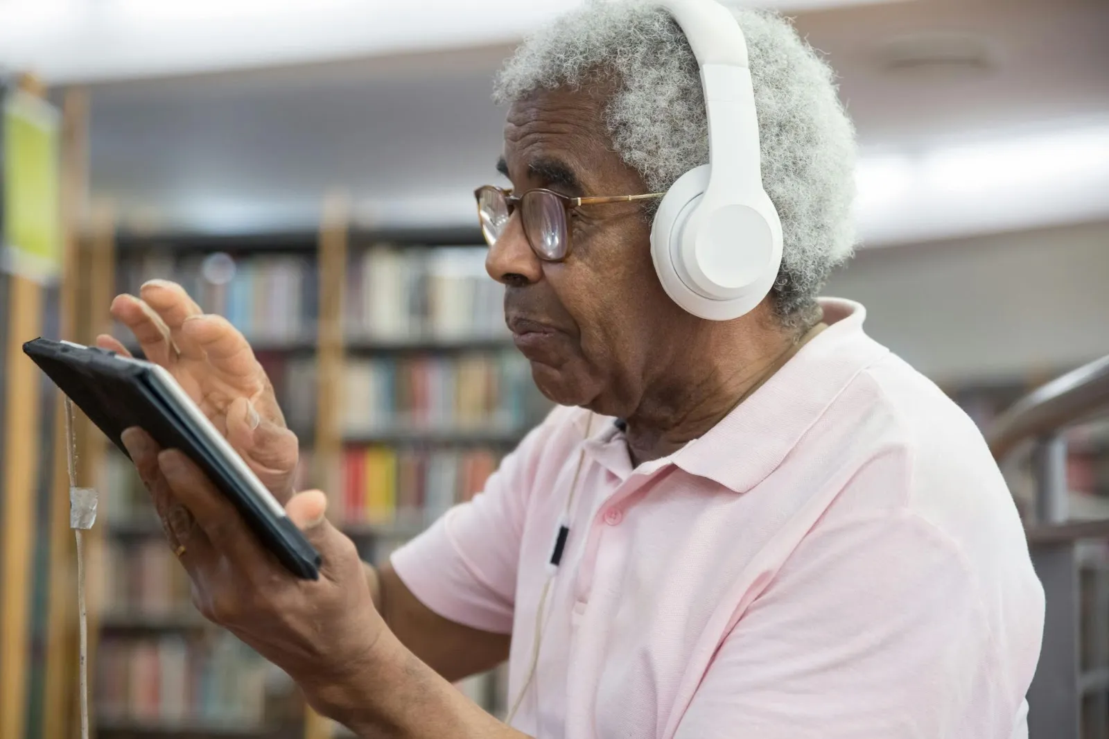 Thumbnail image of an old man with headphones using a tablet device.