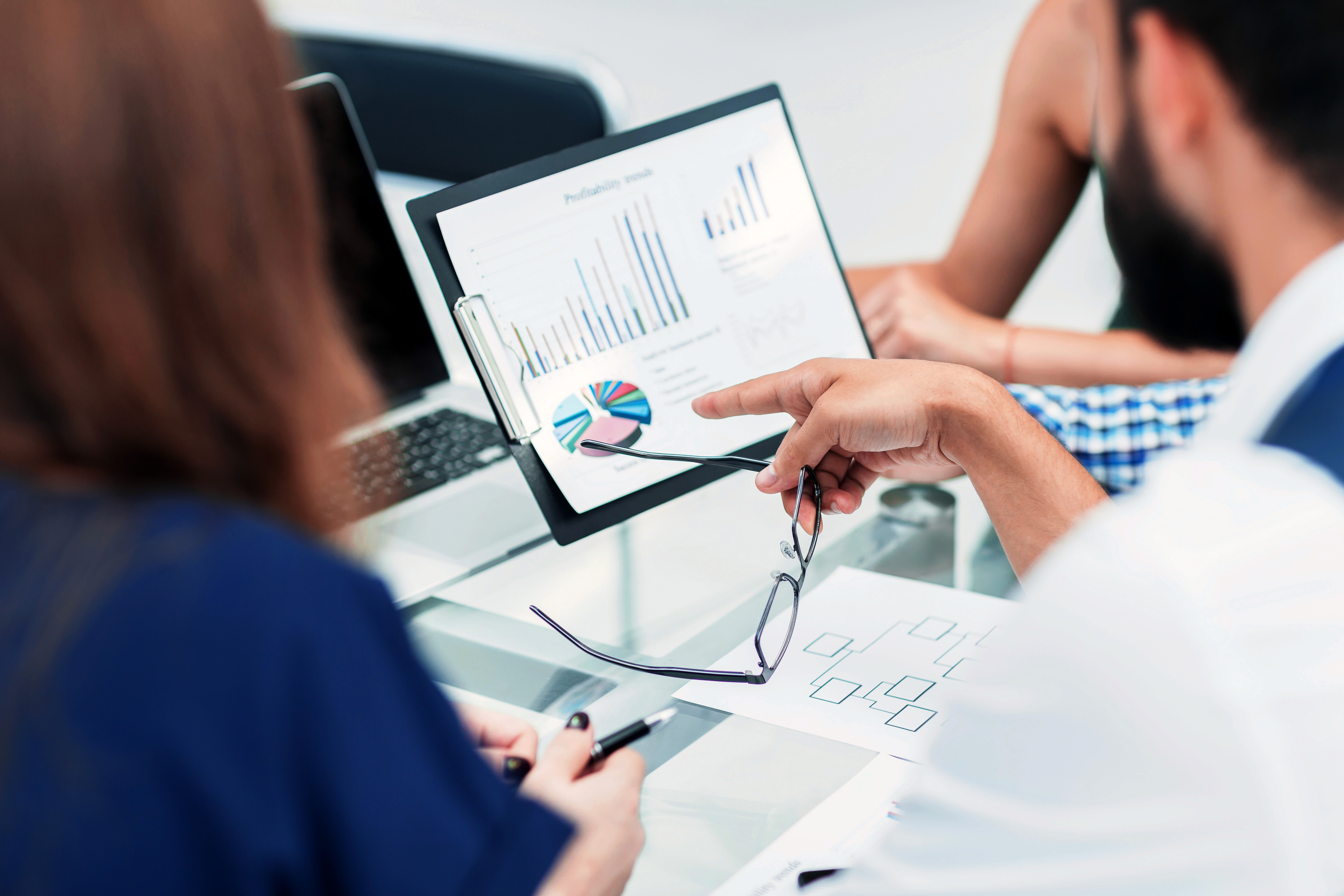 Scientist using a multi-channel pipette to transfer liquid samples in a lab, wearing gloves and surrounded by lab equipment.