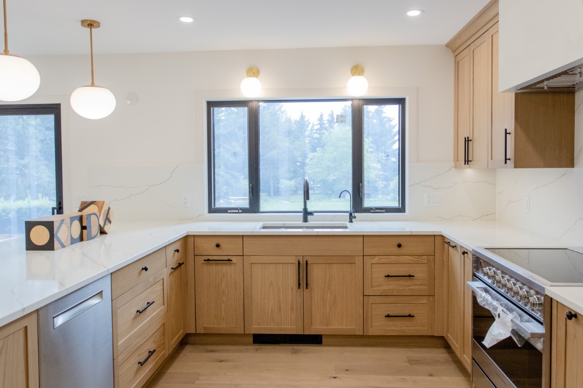 Image of KHD Homes kitchen design with light wood cabinets, marble countertops, and modern appliances layout design.