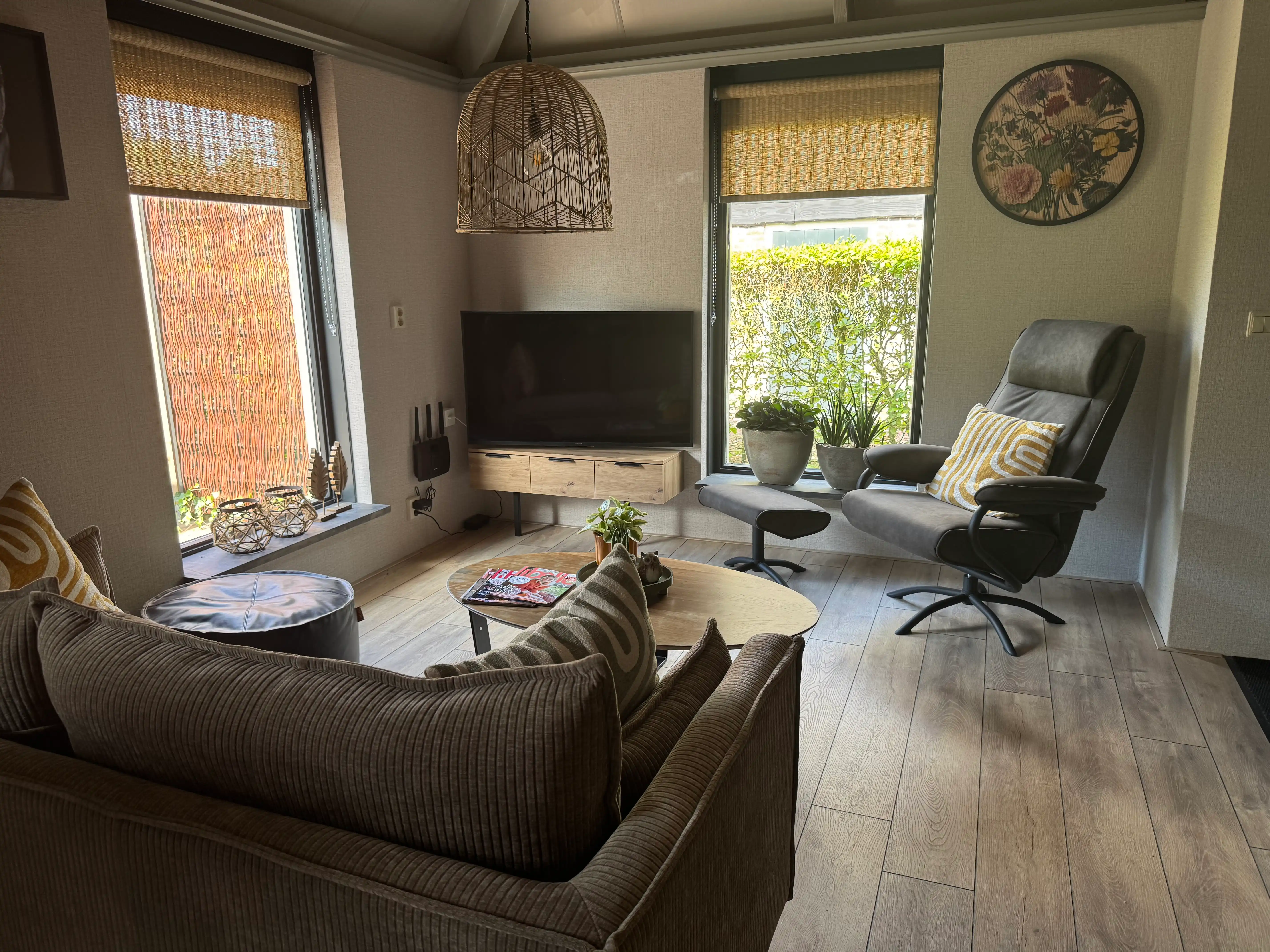 Lichte woonkamer met comfortabele bank, fauteuil en televisie in Dwingeloo