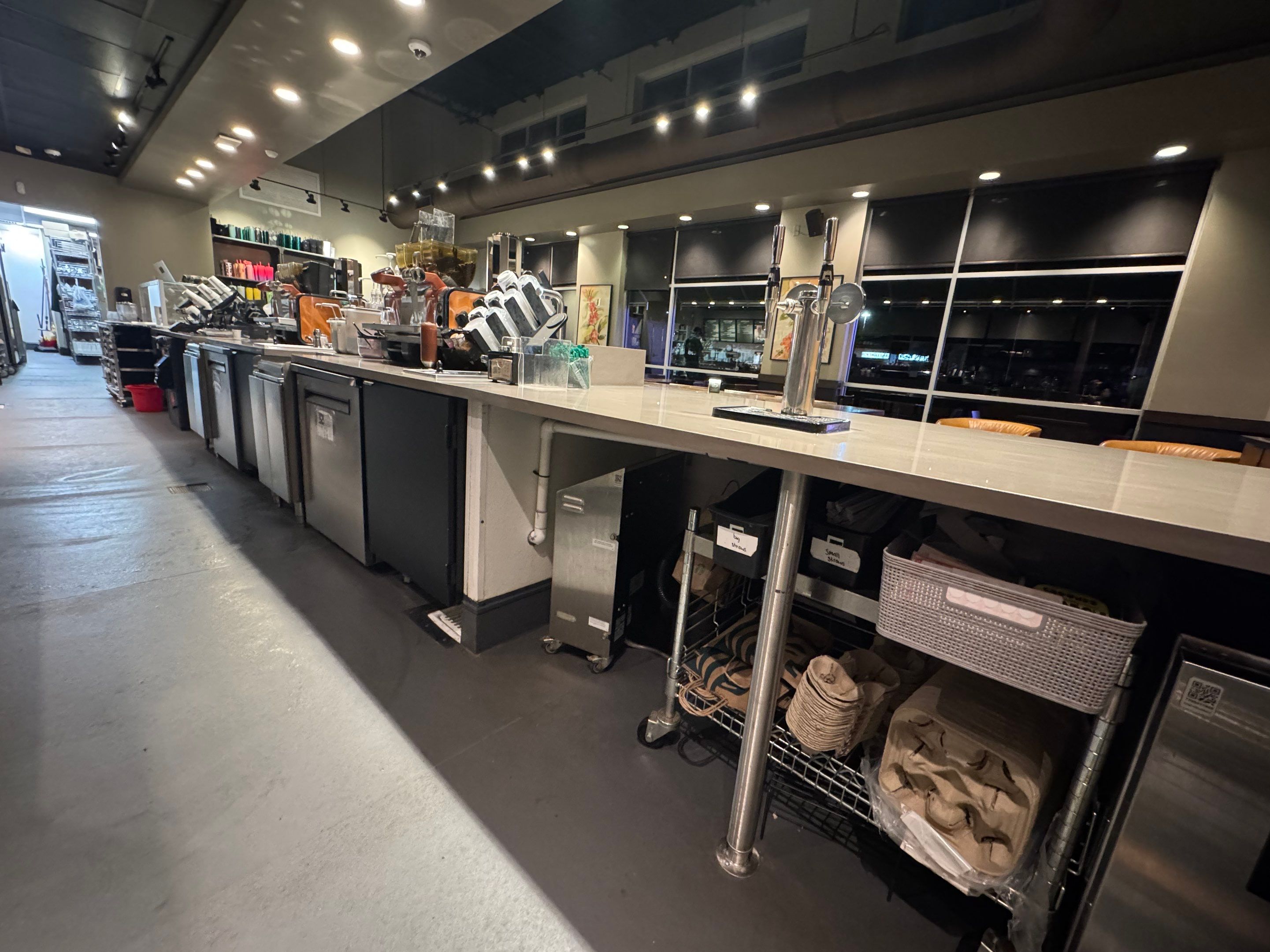 Backside view of a completed Starbucks countertop replacement showing clean installation over beverage equipment, reinforced supports, and organized storage beneath.