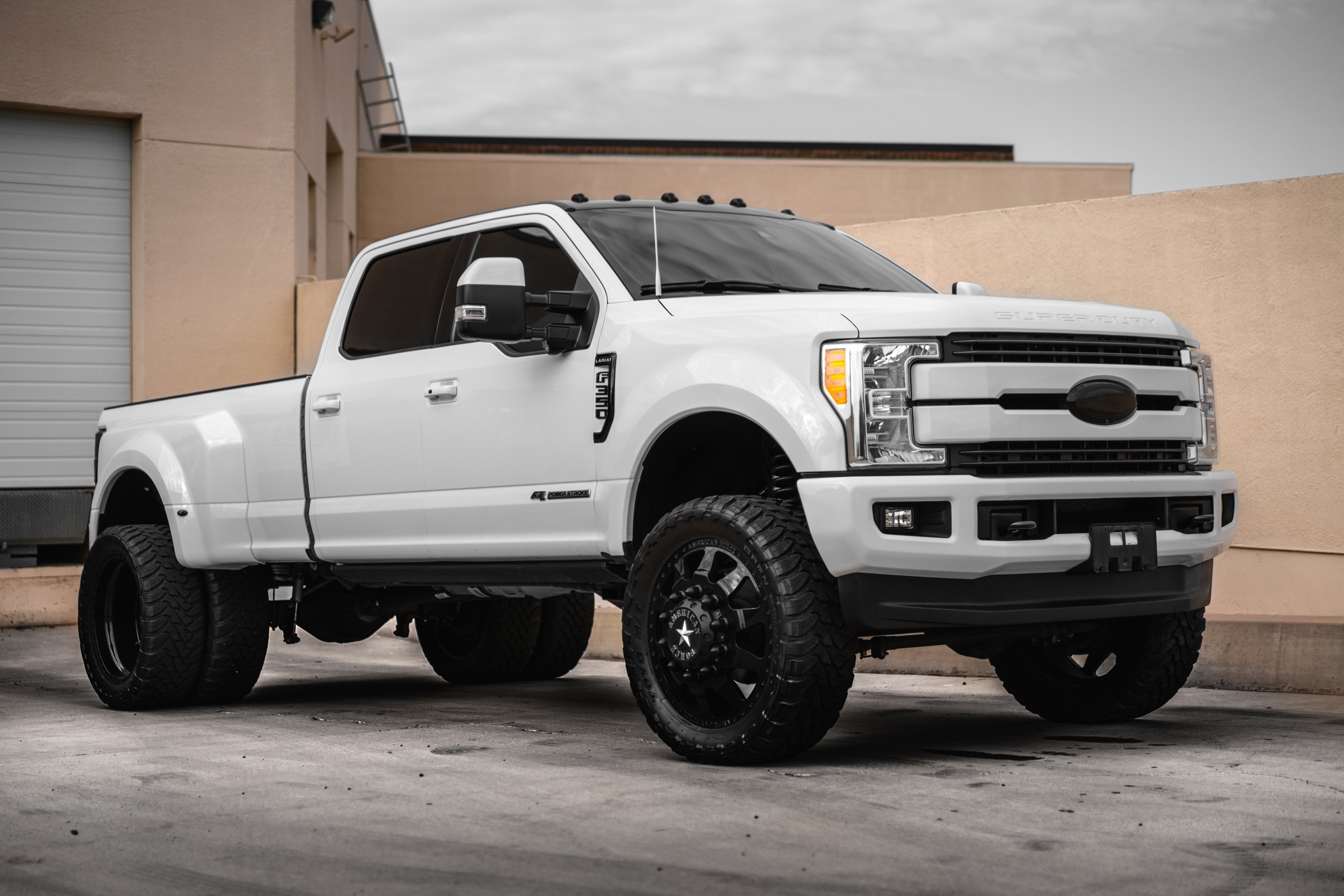Lifted white Ford Super Duty truck parked outside a commercial building in Phoenix, Arizona