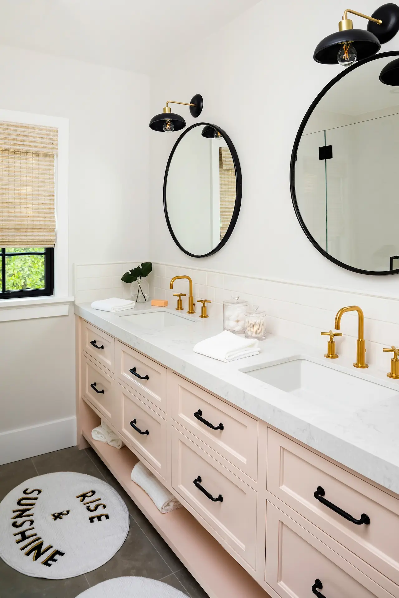 Chic pink vanity with dual oval mirrors and brass fixtures in North Tustin Remodel & Addition. Photo by Molly Rose.