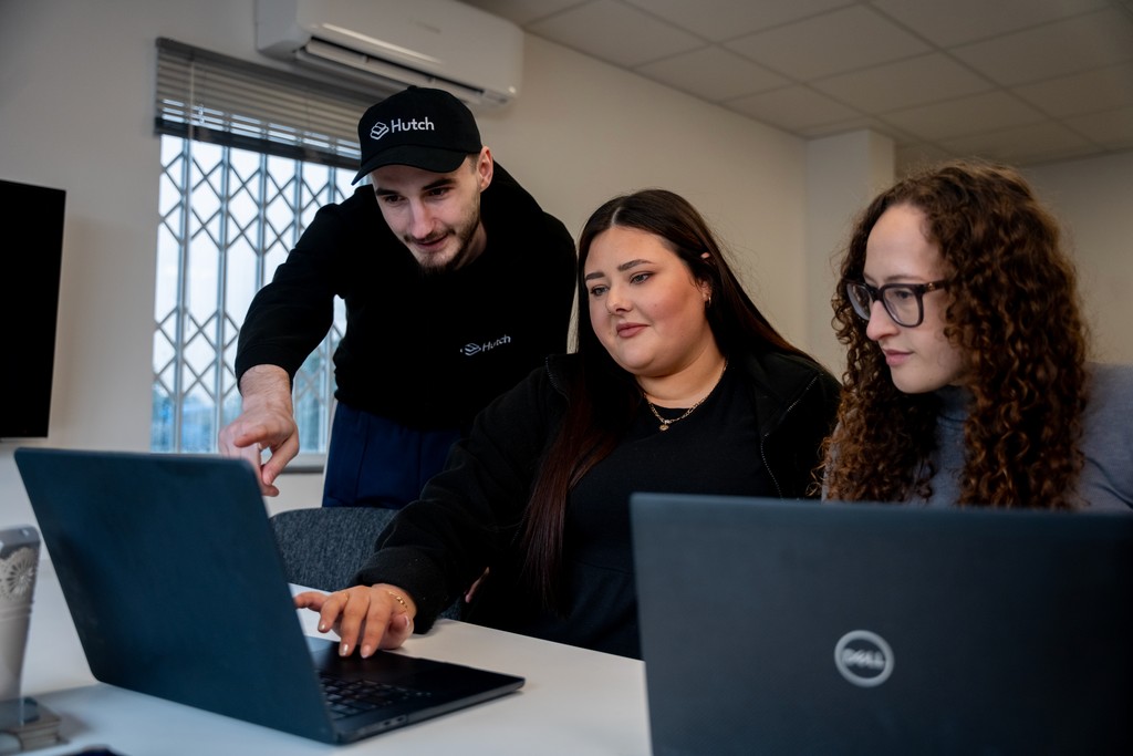 A team of people looking at a laptop