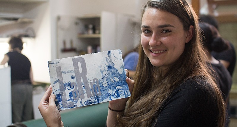 student with paper that says laria