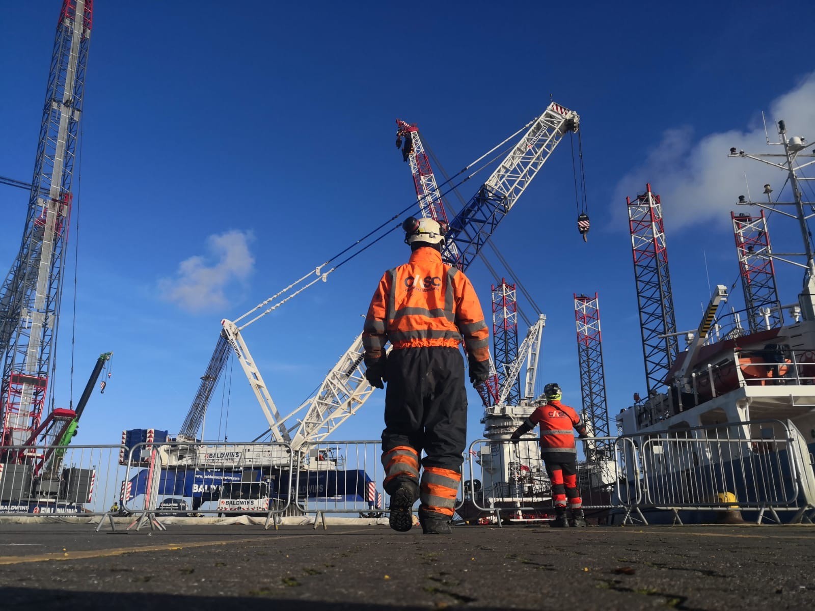 CASC employees guiding the onshore mobilisation of a wind turbine tower using heavy lifting equipment