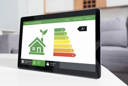 A man stands while two people sit at a table in an office setting, smiling and engaged in conversation. The mood is friendly and collaborative.