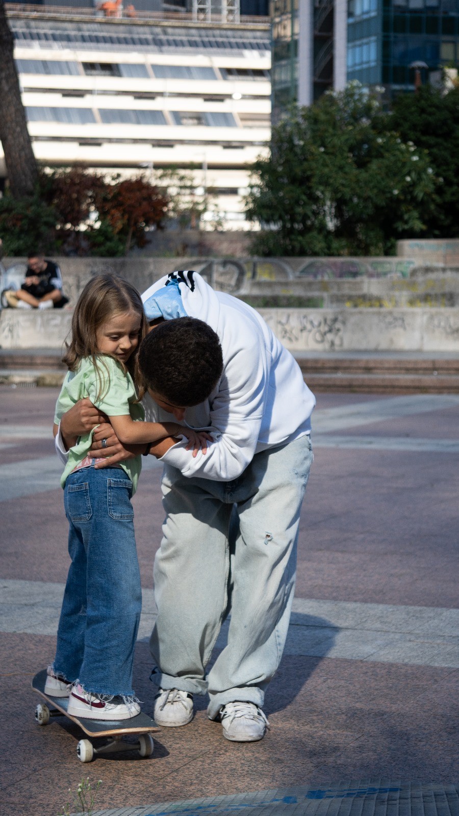 istruttore abbraccia e aiuta bambina a fare skate a napoli