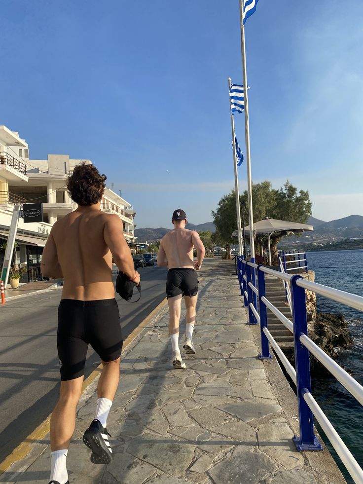 Woman in a denim jacket and sportswear walking through a modern glass pedestrian bridge in an urban cityscape.