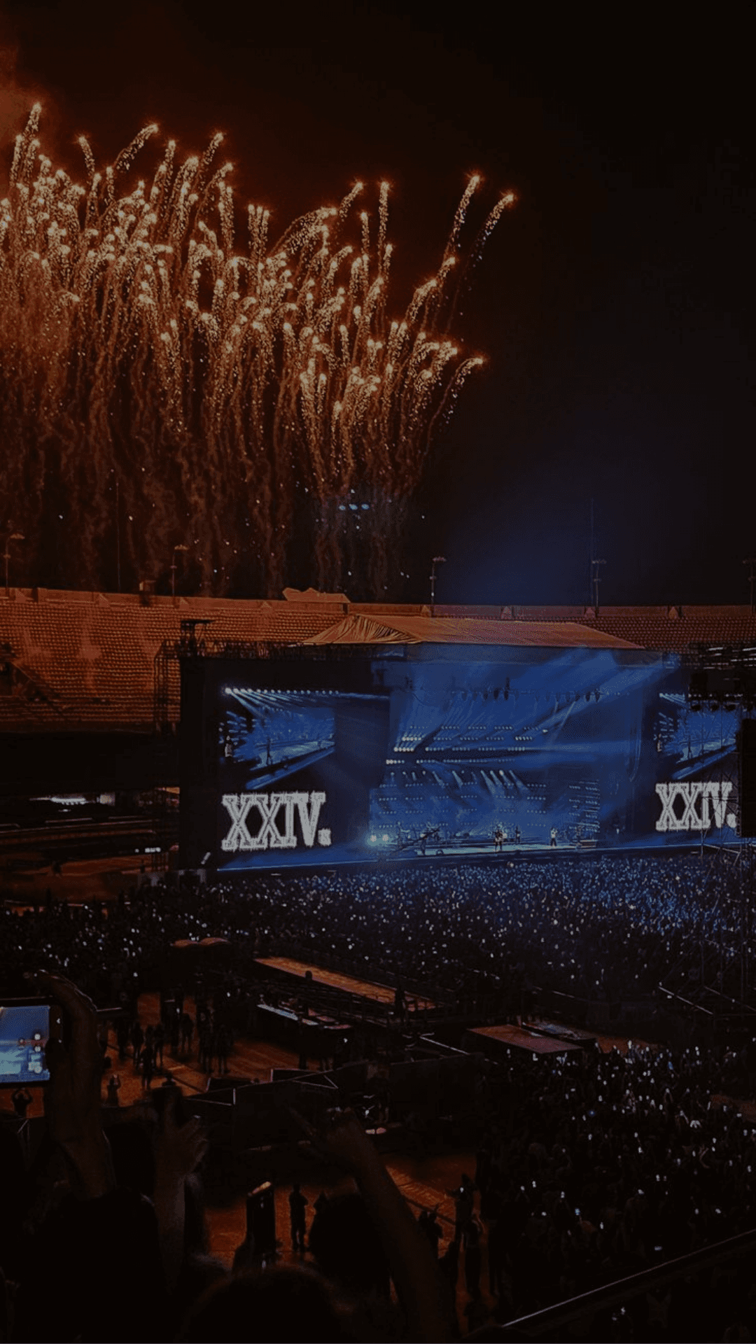 two people sitting on a bench looking at a mountain