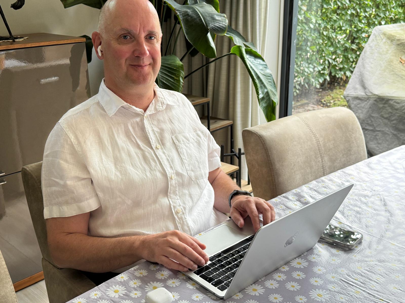 Rik, aan het werk, achter zijn Macbook aan tafel