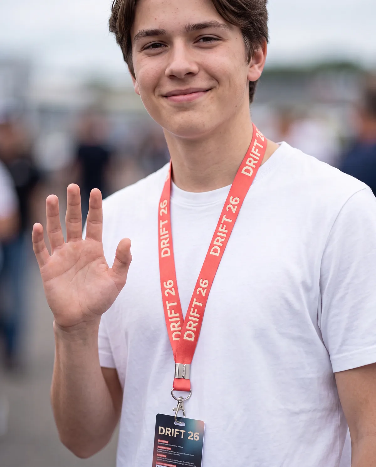 Woven lanyard with badge, worn by an attendee at an outdoor event