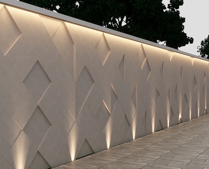 Ranoma stone used in exterior feature wall with geometric relief pattern and integrated architectural lighting