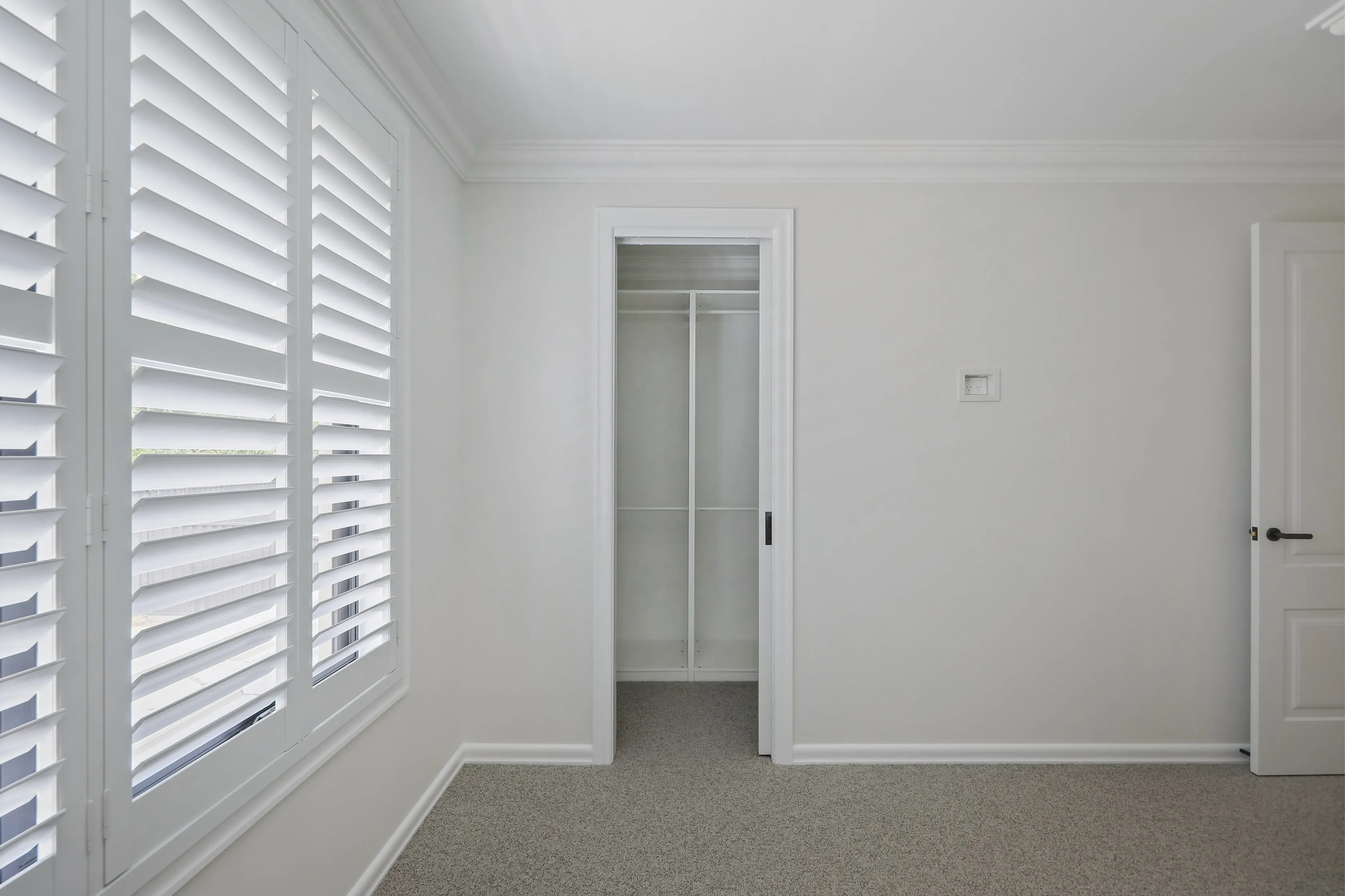 Templestowe bedroom with plantation shutters, carpet and a walk-in robe through a cavity-slider doorway