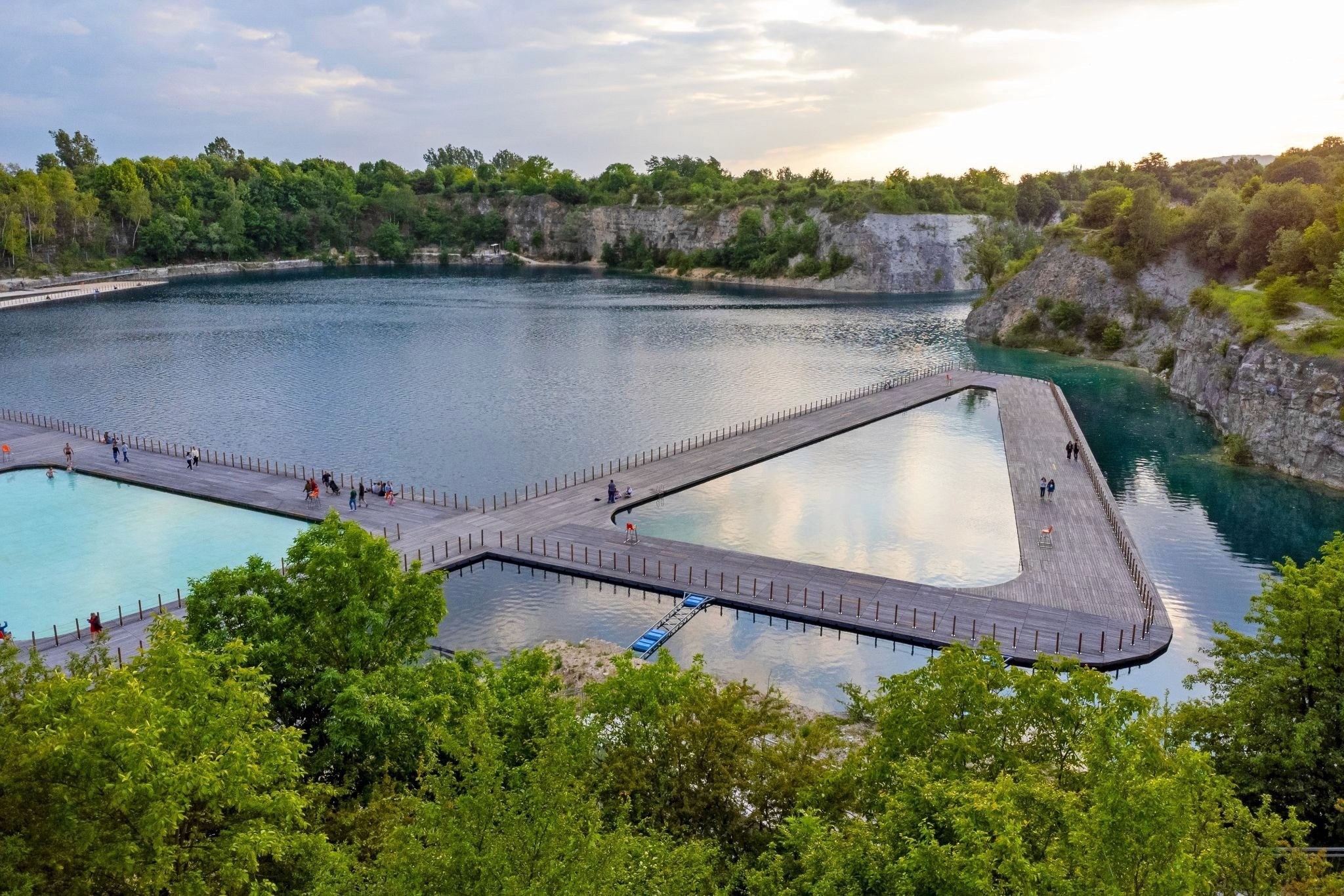 A triangular and rectangular pool floating in the flooded quarry of Zakrzówek Park, Krakow, surrounded by trees