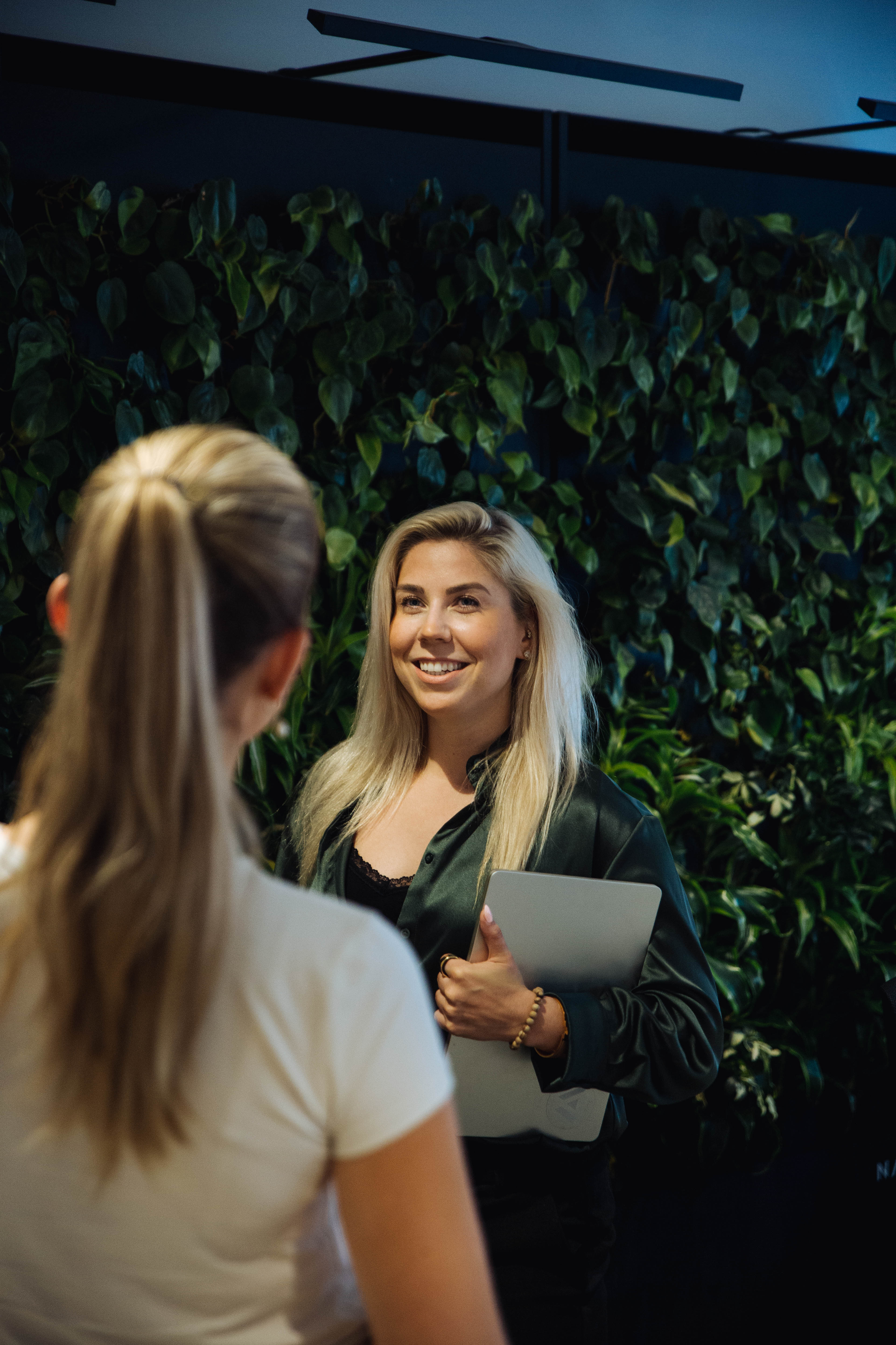 a group of people sitting around a table with laptops