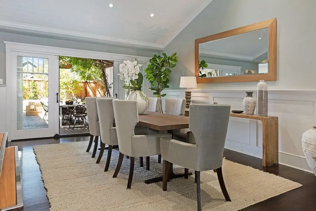 'Port Streets Remodel' dining space with wooden table, grey chairs, and patio view.