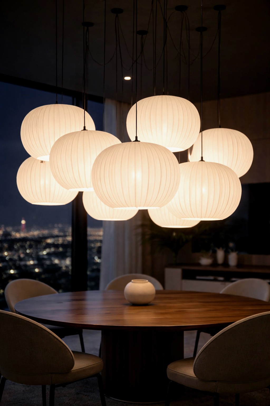 A cluster of brightly glowing lantern lights illuminating a dining area at night, with a blurred city view in the background.