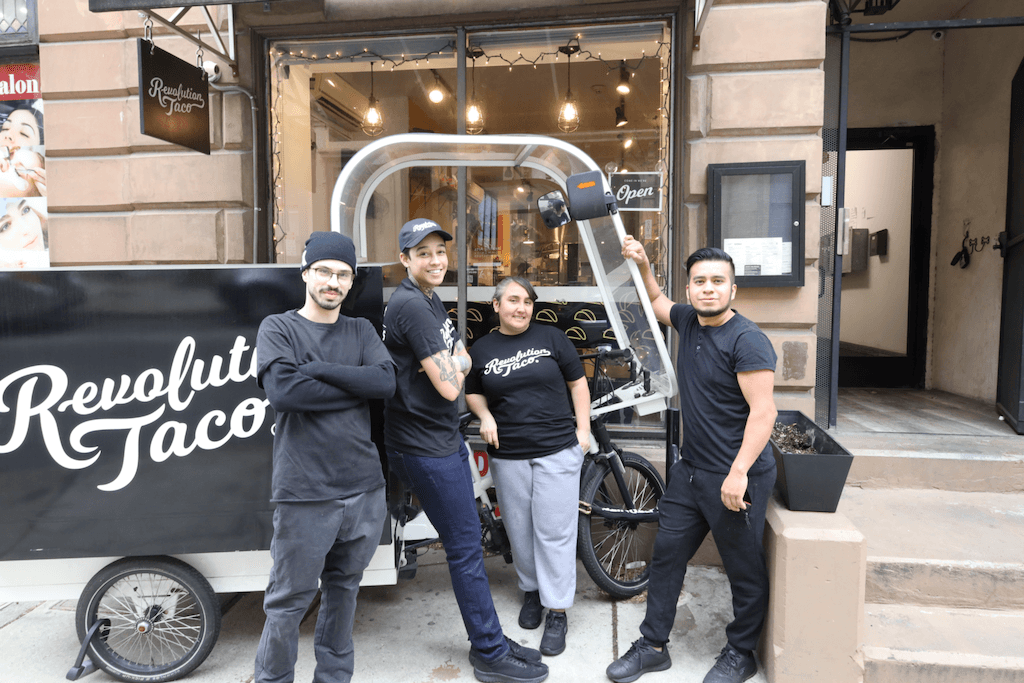 Revolution Taco team posing outside in front of restaurant