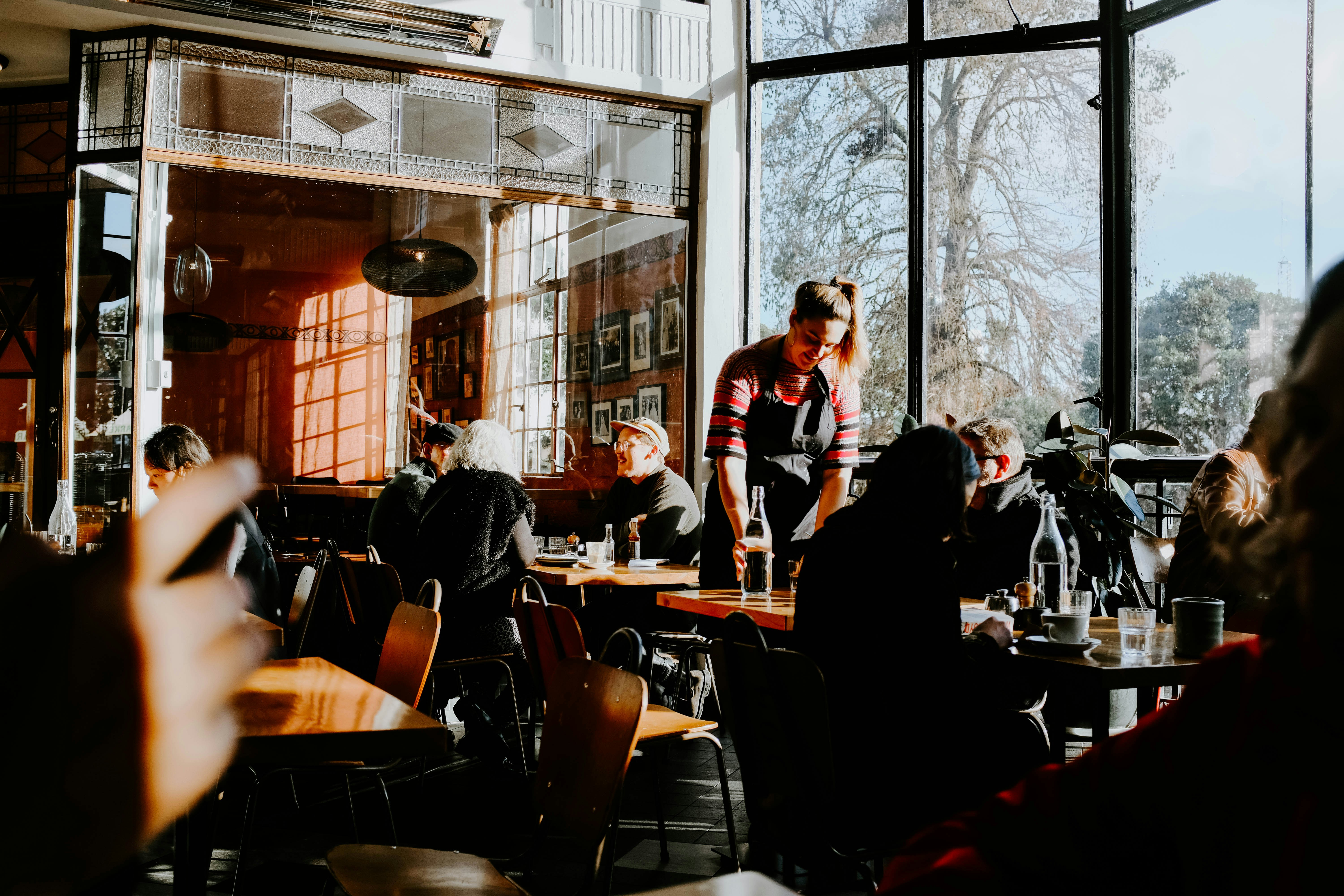 A waiter takes an order from customers at a cafe.