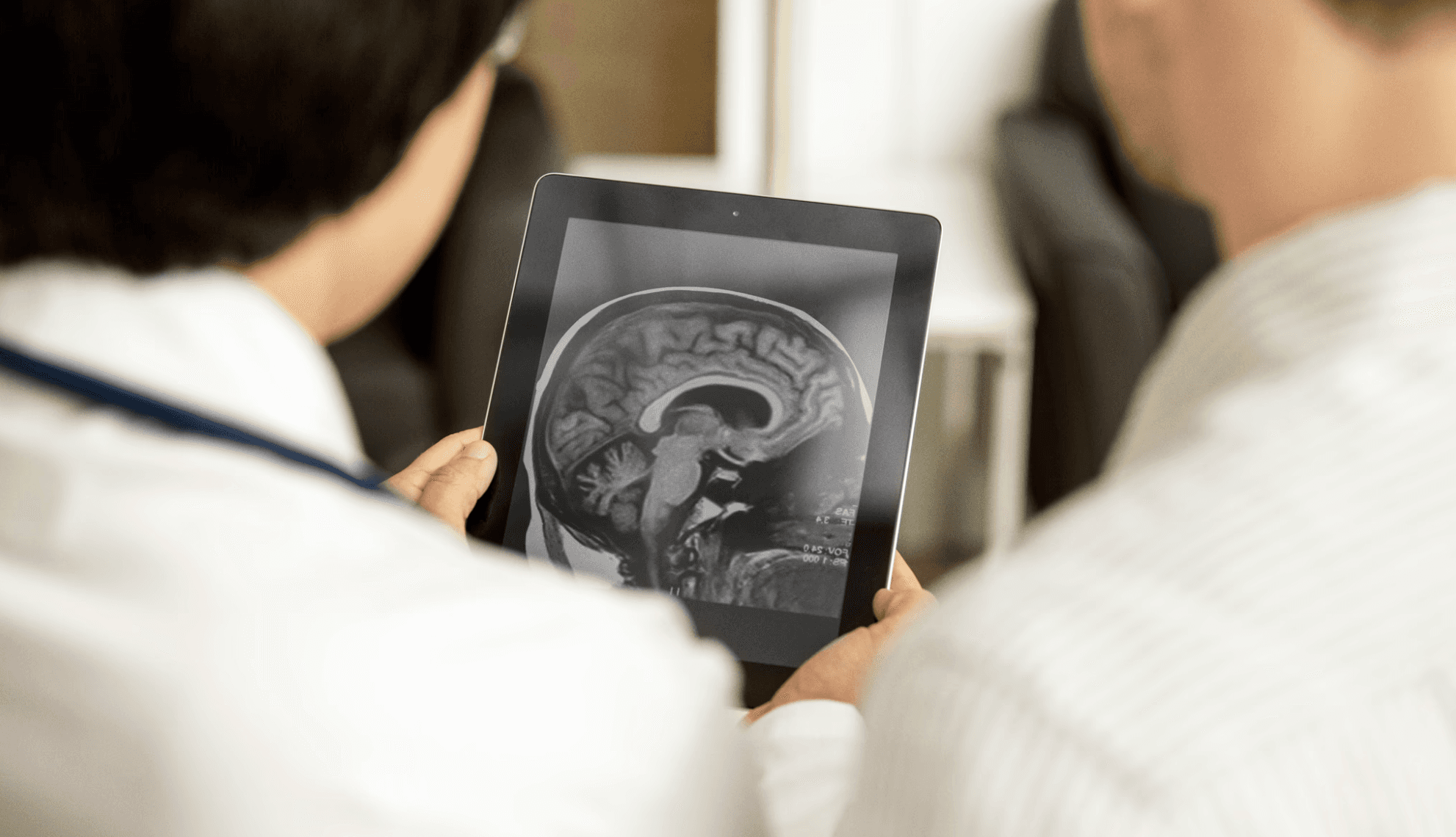 Healthcare professionals reviewing a brain scan on a tablet – representing digital transformation in clinical training.