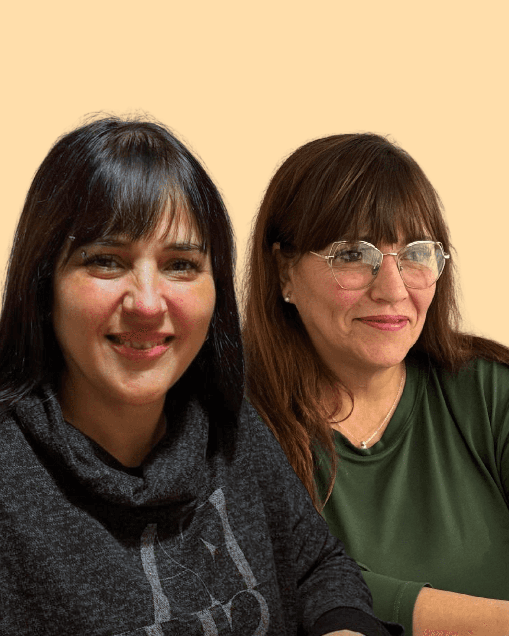 Smiling female therapist with short gray hair, wearing a brown top and a purple shawl, surrounded by a cozy background.