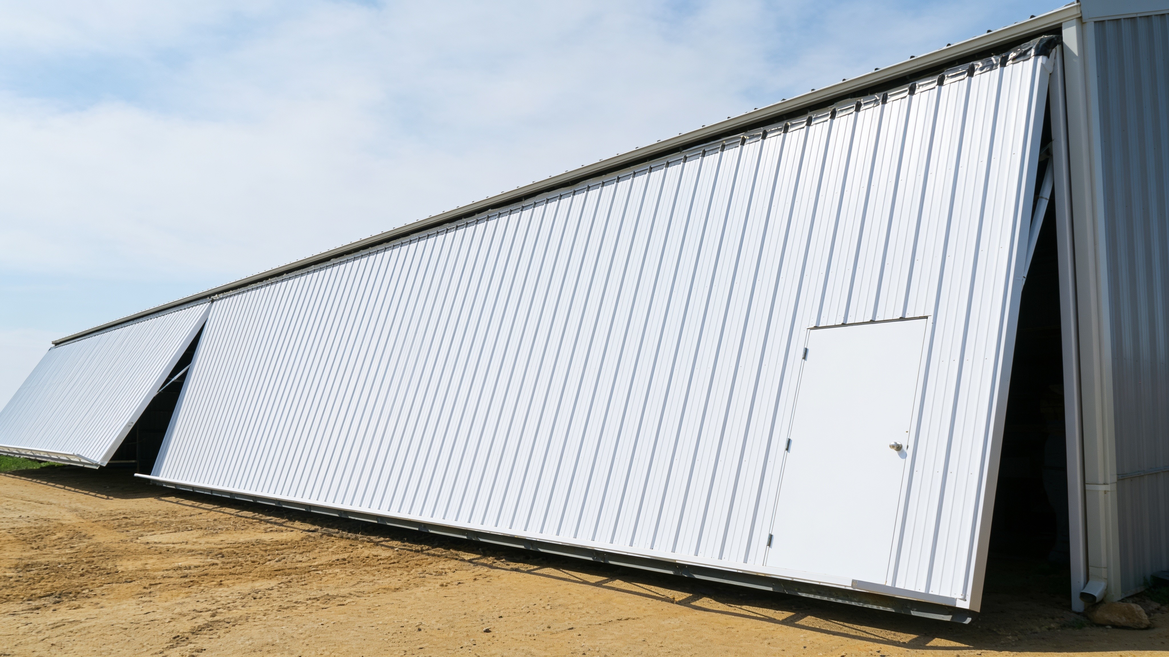 Long metal storage building with an open hydraulic retrofit door