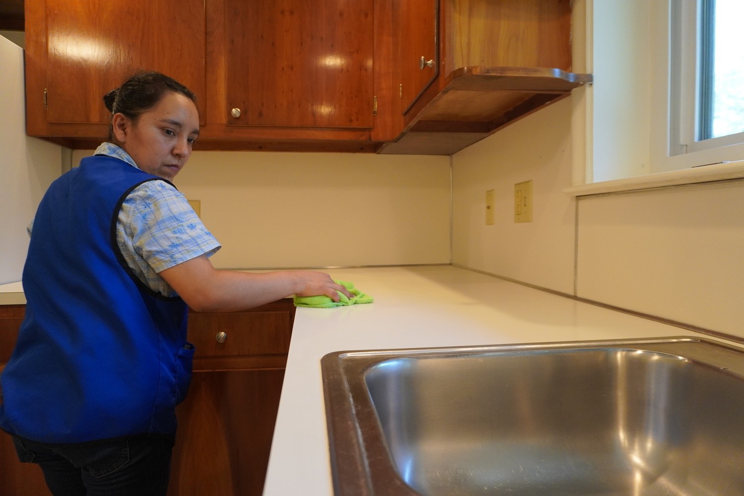 cleaning service company wiping residential kitchen counter